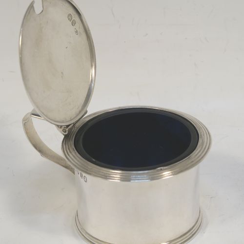 A very elegant Antique Georgian Sterling Silver drum mustard, having a plain cylindrical body, with applied reeded borders, a hinged flat lid with a cast shell thumb-piece, a scroll handle and a blue glass liner. Made by Charles Fox of London in 1833. The dimensions of this fine hand-made antique silver mustard pot are height 6 cms (2.3 inches), diameter 6.5 cms (2.5 inches), and it weighs approx. 90g (3 troy ounces).  