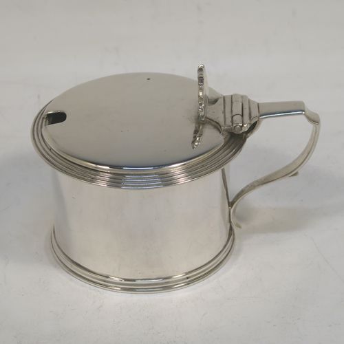 A very elegant Antique Georgian Sterling Silver drum mustard, having a plain cylindrical body, with applied reeded borders, a hinged flat lid with a cast shell thumb-piece, a scroll handle and a blue glass liner. Made by Charles Fox of London in 1833. The dimensions of this fine hand-made antique silver mustard pot are height 6 cms (2.3 inches), diameter 6.5 cms (2.5 inches), and it weighs approx. 90g (3 troy ounces).  