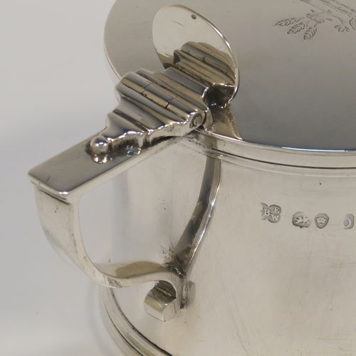 A large and very elegant Antique Georgian Sterling Silver drum mustard, having a plain cylindrical body, with applied reeded borders, a hinged flat lid with a plain oval thumb-piece, a scroll handle and a blue glass liner. This handsome antique silver mustard pot was made by the Barnard Brothers of London in 1829. The dimensions of this fine hand-made antique silver mustard pot are height 7 cms (2.75 inches), diameter 7.5 cms (3 inches), and it weighs approx. 154g (5 troy ounces). Please note that this item is crested on the lid.  