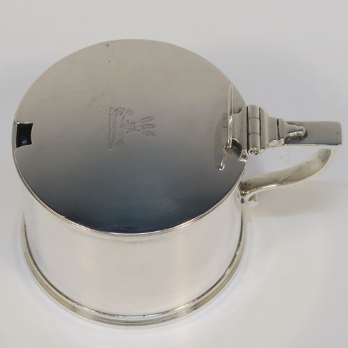 A large and very elegant Antique Georgian Sterling Silver drum mustard, having a plain cylindrical body, with applied reeded borders, a hinged flat lid with a plain oval thumb-piece, a scroll handle and a blue glass liner. This handsome antique silver mustard pot was made by the Barnard Brothers of London in 1829. The dimensions of this fine hand-made antique silver mustard pot are height 7 cms (2.75 inches), diameter 7.5 cms (3 inches), and it weighs approx. 154g (5 troy ounces). Please note that this item is crested on the lid.  