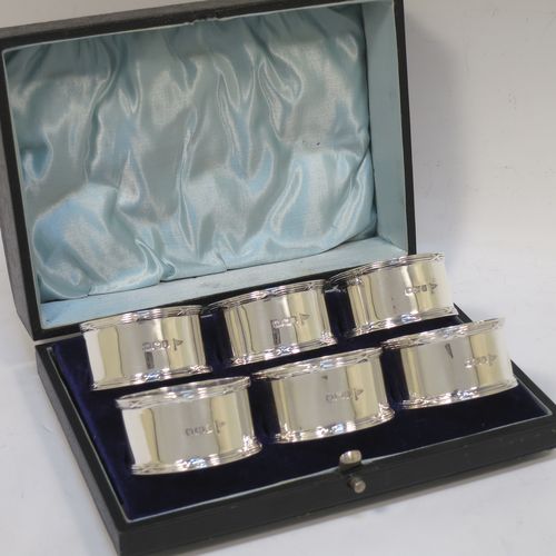 A very handsome Antique Sterling Silver set of six napkin rings, having plain round bodies with straight sides, with applied ribbon and reed borders, all in their original light blue satin and dark-blue velvet-lined presentation box. Made by Walker and Hall of Sheffield in 1915. The dimensions of these fine hand-made antique silver napkin rings are diameter 5 cms (2 inches), height 2.5 cms (1 inch), and they weigh a total of approx. 232g (7.5 troy ounces).  