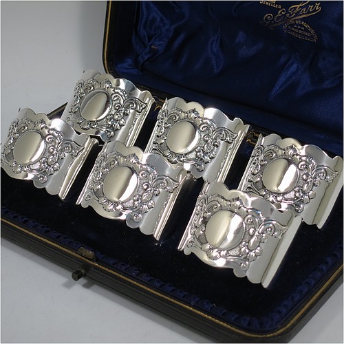 A very pretty Antique Sterling Silver set of six napkin rings, having oval-shaped bodies with hand-engraved floral scroll-work surrounding a vacant cartouche, all in their original dark blue satin and velvet-lined presentation box. Made by George Maudsley Jackson of London in 1895. The dimensions of these fine hand-made antique silver napkin rings are length 5 cms (2 inches), height 3.5 cms (1.3 inch), and they weigh a total of approx. 203g (6.5 troy ounces). Please note that these items are numbered 1 to 6.