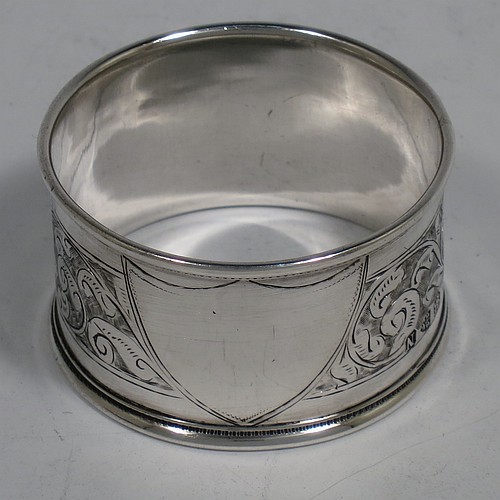 A very pretty Antique Victorian Sterling Silver pair of napkin rings, having round straight-sided bodies with applied borders, each one hand-engraved with a band of floral and scroll-work decoration, with shield-shaped vacant cartouches, and all in their original maroon satin and velvet-lined presentation box. Made by the Deakin Brothers of Chester in 1896. The dimensions of these fine hand-made antique silver napkin rings are diameter 4.5 cms (1.75 inches), height 2.5 cms (1 inch), and they weigh a total of approx. 36g (1.2 troy ounces).    