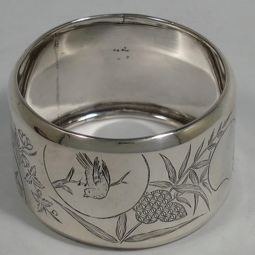 A very pretty Antique Victorian Aesthetic style Sterling Silver pair of napkin rings, having round straight-sided bodies with turned-over borders, and each one hand-engraved differently with Aesthetic decoration of birds, butterflies and bamboo shoots, all in their original cream satin and dark blue velvet-lined presentation box. Made by George Unite of Birmingham in 1881. The dimensions of these fine hand-made antique silver napkin rings are diameter 5 cms (2 inches), height 3 cms (1.25 inches), and they weigh a total of approx. 48g (1.5 troy ounces).    