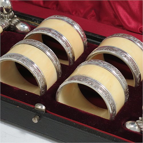 An Antique Victorian Silver-Plated and bone set of four napkin rings and two knife rests, the napkin rings having round straight-sided bodies with applied bands of floral decoration, the knife rests having cast floral supports with button ends, all in their original maroon satin and velvet-lined presentation box. Made by Elkington & Co., in ca. 1880. The dimensions of these fine hand-made antique silver plated and bone napkin rings are diameter 4.5 cms (1.75 inches), height 3 cms (1.25 inch), and the knife rests are 8.5 cms (3.3 inches) long by 4 cms (1.5 inches) high.    