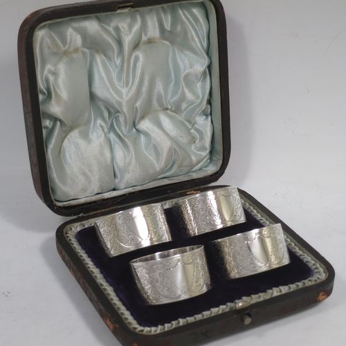 A very pretty Antique Victorian Sterling Silver set of four napkin rings, having round bodies with straight sides, hand-engraved floral and scroll decoration with two vacant shaped shield style cartouches, all in their original light blue satin and dark blue velvet-lined presentation box. Made by Walker and Hall of Sheffield in 1894. The dimensions of these fine hand-made antique silver-plated napkin rings are diameter 4.5 cms (1.75 inches), height 2.5 cms (1 inch), and they weigh a total of approx. 119g (3.8 troy ounces).   