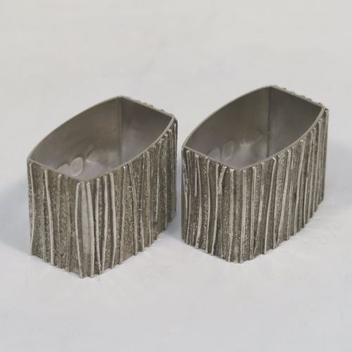 A very unusual Modernistic style Sterling Silver pair of napkin rings, having straight sided rectangular bodies with three sides having a cast bark-like finish, and the fourth side with large spread hallmarks including the Queens Jubilee mark. These beautiful silver napkin rings were made by Graham Watling of London in 1977. The dimensions of these fine hand-made silver napkin rings are length 4.5 cms (1.75 inches), height 3 cms (1.25 inches), and they weigh a total of approx. 93g (3 troy ounces).   