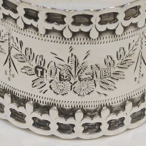 A very unusual Antique Edwardian Sterling Silver pair of napkin rings, having straight sided round bodies with applied fleur-de-lis borders, and hand-engraved floral decoration surrounding a vacant cartouche. These beautiful silver napkin rings were made by Thomas Hayes of Birmingham in 1906. The dimensions of these fine hand-made silver napkin rings are diameter 4.5 cms (1.75 inches), height 3.5 cms (1.3 inches), and they weigh a total of approx. 62g (2 troy ounces).  