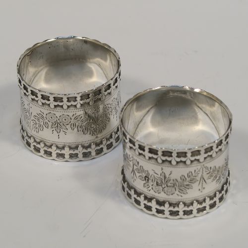 A very unusual Antique Edwardian Sterling Silver pair of napkin rings, having straight sided round bodies with applied fleur-de-lis borders, and hand-engraved floral decoration surrounding a vacant cartouche. These beautiful silver napkin rings were made by Thomas Hayes of Birmingham in 1906. The dimensions of these fine hand-made silver napkin rings are diameter 4.5 cms (1.75 inches), height 3.5 cms (1.3 inches), and they weigh a total of approx. 62g (2 troy ounces).  