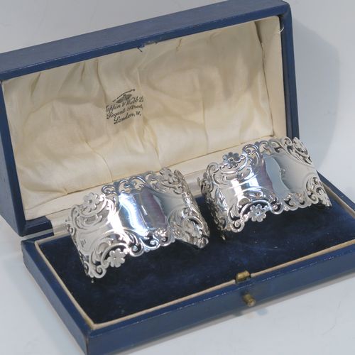 A very pretty and heavy Antique Victorian Sterling Silver pair of napkin rings, having oval straight-sided bodies with hand-pierced and engraved floral and scroll decoration, all in their original cream  satin and dark blue velvet-lined presentation box. These beautiful antique silver napkin rings were made by Alexander Clarke of Sheffield in 1901. The dimensions of these fine hand-made antique silver napkin rings are length 6 cms (2.25 inches), height 3.5 cms (1.3 inches), and they weigh a total of approx. 93g (3 troy ounces). Please note that these napkin rings are numbered one and two. 