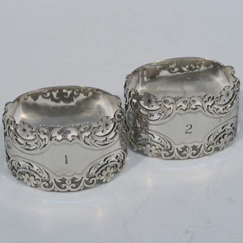 A very pretty and heavy Antique Victorian Sterling Silver pair of napkin rings, having oval straight-sided bodies with hand-pierced and engraved floral and scroll decoration, all in their original cream  satin and dark blue velvet-lined presentation box. These beautiful antique silver napkin rings were made by Alexander Clarke of Sheffield in 1901. The dimensions of these fine hand-made antique silver napkin rings are length 6 cms (2.25 inches), height 3.5 cms (1.3 inches), and they weigh a total of approx. 93g (3 troy ounces). Please note that these napkin rings are numbered one and two. 