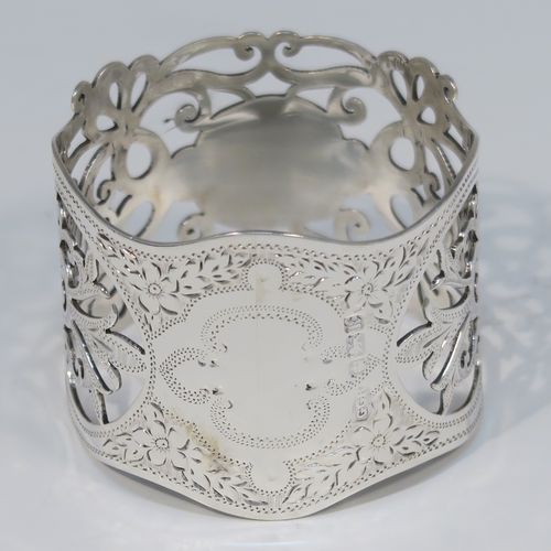 A very pretty Antique Edwardian Art Nouveau style Sterling Silver pair of napkin rings, having round straight-sided bodies with hand-pierced and engraved floral and scroll decoration, all in their original dark blue satin and velvet-lined presentation box. These beautiful antique silver napkin rings were made by George Rhoden of Sheffield in 1909. The dimensions of these fine hand-made antique silver napkin rings are diameter 4.5 cms (1.75 inches), height 4 cms (1.5 inches), and they weigh a total of approx. 63g (2 troy ounces).   