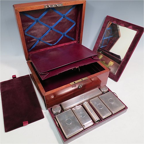 An Antique Victorian Sterling Silver travelling Necessaire, having two cologne bottles, two large bottles, two small bottles, a hair brush, two clothes brushes, an inkwell, a shaving brush, a soap box, a folding desk mirror, and internal space for letters, pens, and jewellery, all fitted in an original maroon velvet-lined oak box with brass fittings. All silver items have engine-turned decoration with central cartouches that are crested, and are made by Thomas Johnson of London in 1862. The dimensions of the solid oak box are 30.5 cms (12 inches), height 14 cms (5.5 inches), and width 24 cms (9.5 inches). Please note that the box is slightly damaged, but otherwise in excellent condition. All silver and crystal items are original with full matching hallmarks.