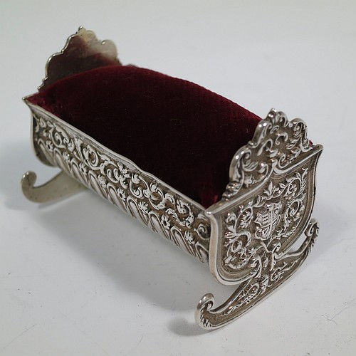 An Antique Victorian Sterling Silver pin cushion, in the form of a babies rocking crib, with hand-chased floral and fluted decoration, together with a maroon velvet covered cushion. Made by Saunders and Shepherd of Birmingham in 1896. The dimensions of this fine hand-made antique silver pin cushion are length 6 cms (2.3 inches), width 3.5 cms (1.3 inches), height 4 cms (1.5 inches), and it weighs approx. 33g (1 troy ounces).   