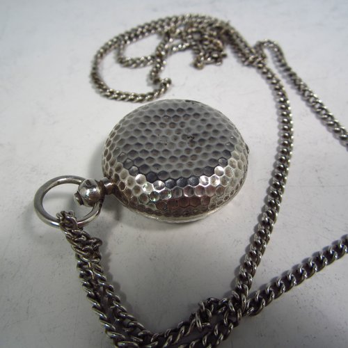 An Antique Edwardian Sterling silver single Sovereign case and original chain, having a round body with hand-hammered decoration and in the shape of a Hunter fob watch, with hinged lid, internal sprung mechanism which is in working order, and push-button clasp, all made by Alexander Davenport of Birmingham in 1908. The dimensions of this fine hand-made silver sovereign case are length 4 cms (1.5 inches), and it weighs a total of 39g (1.25 troy ounces).   