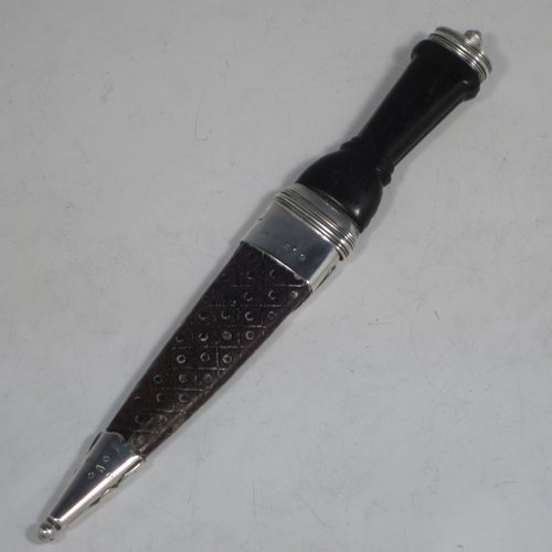 A Scottish Antique Victorian Sterling Silver Sgian Dubh ceremonial knife and scabbard, having a hand-made leather scabbard with Cymric style silver mounts, a black hand-carved Bog-Oak handle with finial and matching decoration, and an original steel blade. Made by James Ross of Edinburgh in 1888. The dimensions of this fine hand-made silver Sgian Dubh are length 23 cms (9 inches), and width 3 cms (1.25 inches).