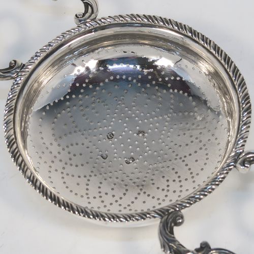 A very handsome Antique Georgian Sterling Silver lemon strainer, having a round hand-pierced main bowl body with an applied rope-twist border, and two cast scroll side-handles with shell terminals. This beautiful and original Georgian silver lemon strainer was made by Charles Aldridge and Henry Green of London in 1772. The dimensions of this fine hand-made antique silver lemon strainer are length 25,5 cms (10 inches), diameter of bowl 11 cms (4.25 inches), and it weighs approx. 117g (3.8 troy ounces).