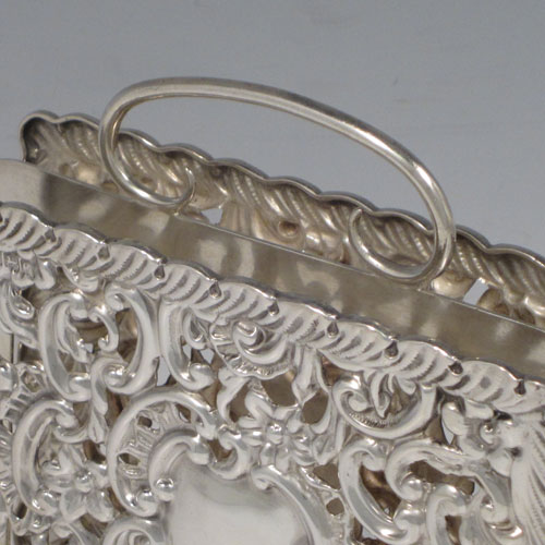 Antique Edwardian rare sterling silver letter rack in the form of a magazine holder, having hand-chased and pierced sides with floral decoration, a central divider with loop handle, and sitting on four scroll feet. Made by Synyer and Beddoes of Birmingham in 1902. The dimensions of this fine hand-made silver letter holder are height 13 cms (5 inches), width 11.5 cms (4.5 inches), depth 7 cms (2.75 inches), and it weighs approx. 168g (5.4 troy ounces).