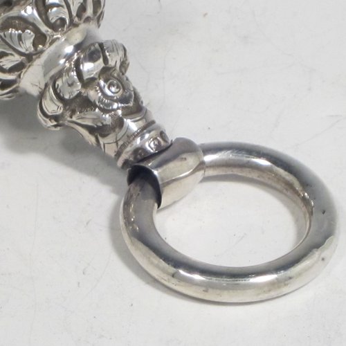 Antique Victorian sterling silver babies rattle, having a round baluster body with hand-chased floral decoration, seven attached bells, a plain round teething ring, and a whistle end. Made in Birmingham in 1870. The dimensions of this fine hand-made silver babies rattle are length 13.5 cms (5.3 inches), width 5 cms (2 inches), and it weighs approx. 67g (2.2 troy ounces).