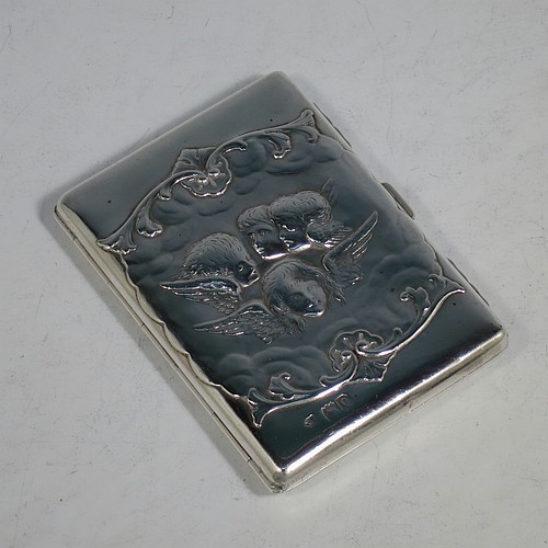 An Antique Victorian Sterling Silver Aide de Memoire and calling card case, having a rectangular body with hand-chased winged cherubs and floral decoration, hinged on one side and with a clasp on the other, and lined with light brown leather pockets. Made by William Comyns of London in 1898. The dimensions of this fine hand-made antique silver Aide de Memoire card case are length 10 cms (4 inches), width 7.5 cms (3 inches), and it weighs approx. 120g (3.9 troy ounces).    