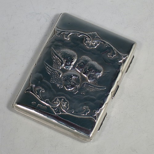 An Antique Victorian Sterling Silver Aide de Memoire and calling card case, having a rectangular body with hand-chased winged cherubs and floral decoration, hinged on one side and with a clasp on the other, and lined with light brown leather pockets. Made by William Comyns of London in 1898. The dimensions of this fine hand-made antique silver Aide de Memoire card case are length 10 cms (4 inches), width 7.5 cms (3 inches), and it weighs approx. 120g (3.9 troy ounces).    