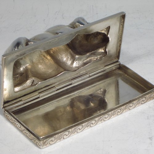 A rare Antique Edwardian Sterling silver table box, in the shape of a dog lying down on all four paws, with a hinged lid, and hand-engraved floral decoration running around the base. Originally made by Berthold Muller of Germany and carrying import marks for London in 1907. The dimensions of this fine hand-made antique silver Dog box are length 10 cms (4 inches), width 4.5 cms (1.75 inches), height 4 cms (1.5 inches), and it weighs approx. 144g (4.6 troy ounces).   