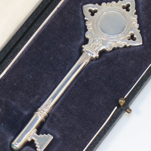 A handsome Sterling Silver 21st key to life, having a cast body with a hand-chased Gothic style handle, a plain shank, hand-chased collars, and a plain key bit, all in its original cream satin and dark-blue velvet-lined presentation box. Made by Vaughton and Sons of Birmingham in 1932. The dimensions of this fine hand-made silver 21st key to life are length 11 cms (4.3 inches) and it weighs approx. 43g (1.4 troy ounces).  