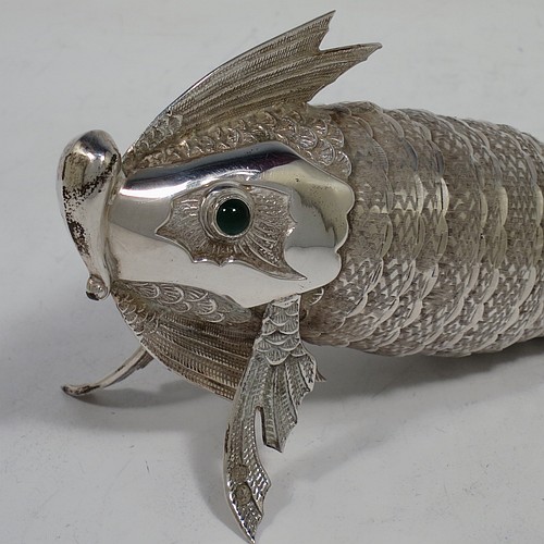 A very pretty Antique Edwardian Silver Articulated fish, having hand-chased scales and fins, and with two green cabochon glass eyes. Made in Spain in ca. 1900. On one of the lower fins you can see the hallmark of a Pentagram that is a Spanish quality mark indicating a minimum of 915 Silver purity (Sterling Standard is 925). The dimensions of this fine hand-made antique Articulated Silver fish are length 20 cms (8 inches), height 7.5 cms (3 inches), and it weighs approx. 138g (4.4 troy ounces).