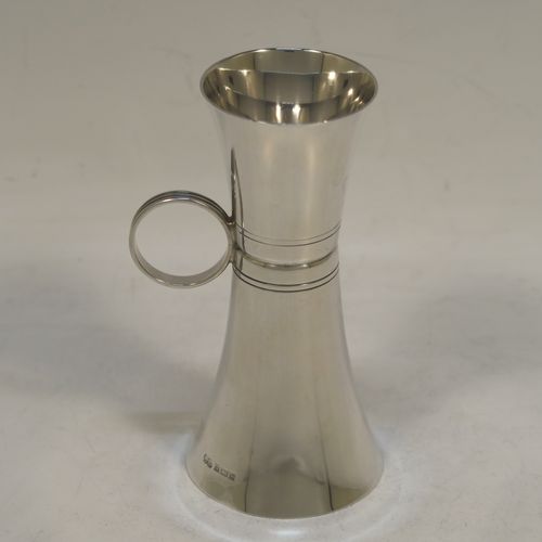 An elegant Sterling Silver double whisky spirit jigger measure cup, having a plain round body with tapering sides, a loop side-handle with hand-engraved reeded decoration, with 50ml and 25ml cups. Made by Elkington and Co., of Birmingham in 1966. The dimensions of this fine hand-made silver double spirit jigger measure cup are height 10.5 cms (4.2 inches), diameter at widest end 5 cms (2 inches), and it weighs approx. 55g (1.8 troy ounces).