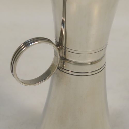 An elegant Sterling Silver double whisky spirit jigger measure cup, having a plain round body with tapering sides, a loop side-handle with hand-engraved reeded decoration, with 50ml and 25ml cups. Made by Elkington and Co., of Birmingham in 1966. The dimensions of this fine hand-made silver double spirit jigger measure cup are height 10.5 cms (4.2 inches), diameter at widest end 5 cms (2 inches), and it weighs approx. 55g (1.8 troy ounces).