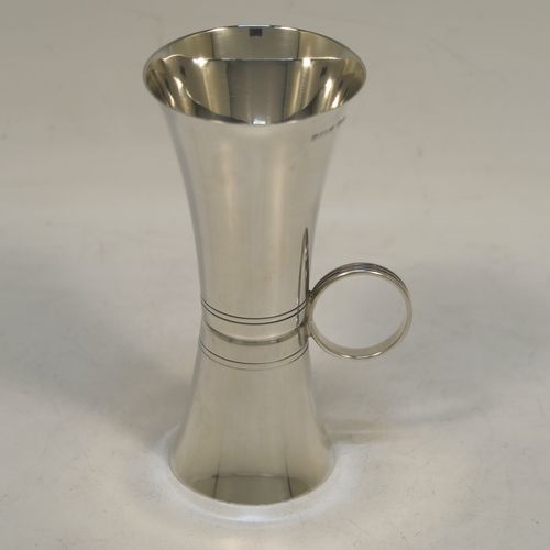 An elegant Sterling Silver double whisky spirit jigger measure cup, having a plain round body with tapering sides, a loop side-handle with hand-engraved reeded decoration, with 50ml and 25ml cups. Made by Elkington and Co., of Birmingham in 1966. The dimensions of this fine hand-made silver double spirit jigger measure cup are height 10.5 cms (4.2 inches), diameter at widest end 5 cms (2 inches), and it weighs approx. 55g (1.8 troy ounces).