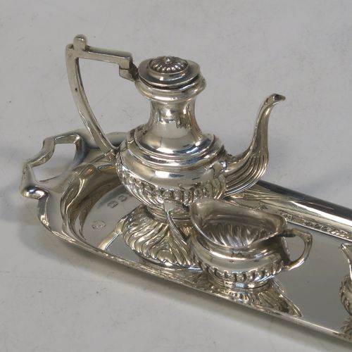 An elegant Sterling Silver miniature tea and coffee service in a Queen Anne half-fluted style, consisting of a coffee pot, tea pot, sugar bowl, milk jug, and a two-handled tray. All made by D. J. Silver Ltd., of London in 1973 (the tray for 1969). The dimensions of this fine hand-made silver miniature tea and coffee set are are height 4 cms (1.5inches), length 14.5 cms (5.75 inches), width 4 cms (1.5 inches), and it weighs approx. 67g (2.2 troy ounces).   