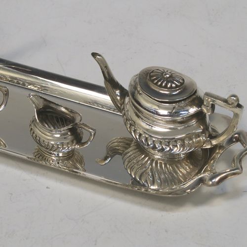 An elegant Sterling Silver miniature tea and coffee service in a Queen Anne half-fluted style, consisting of a coffee pot, tea pot, sugar bowl, milk jug, and a two-handled tray. All made by D. J. Silver Ltd., of London in 1973 (the tray for 1969). The dimensions of this fine hand-made silver miniature tea and coffee set are are height 4 cms (1.5inches), length 14.5 cms (5.75 inches), width 4 cms (1.5 inches), and it weighs approx. 67g (2.2 troy ounces).   