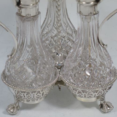 A very pretty Antique Victorian Sterling Silver oil and vinegar set, having three hand-cut crystal bottles with silver mounts, stoppers, and bead-edged scroll handles. All sitting in a hand-pierced frame with matching bead-work, a twisted central and hand-pierced handle, and all sitting on three cast claw and ball feet. Made by Martin Hall and Co., of Sheffield in 1857. The dimensions of this fine hand-made antique silver and crystal oil and vinegar set are height 19 cms (7.5 inches), width 11 cms (4.3 inches), and the frame  weighs approx. 170g (5.5 troy ounces).    