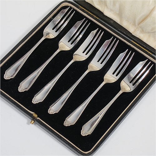 A Sterling Silver set of six pastry forks, having a single-struck reeded Louis pattern handle, and three tined forks, all in their original cream satin and black velvet-lined presentation box. Made by the Cooper Brothers of Sheffield in 1926. The dimensions of these fine hand-made silver pastry forks are length 13 cms (5.25 inches), and they weigh a total of 92g (3 troy ounces).    