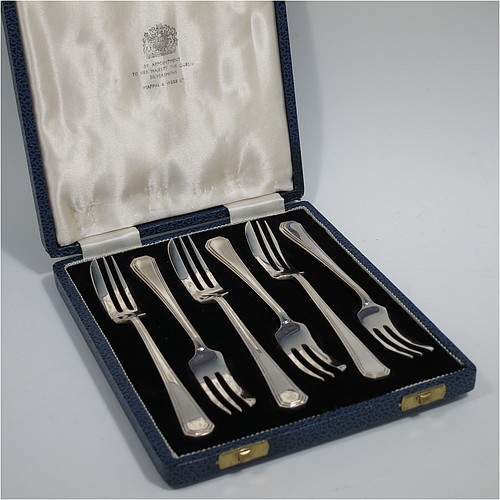 A Sterling Silver Art Deco style set of six pastry forks, having a double-struck plain reeded Athenian pattern handle, and three tined forks, all in their original cream satin and black velvet-lined presentation box. Made by Mappin and Webb of Sheffield in 1963. The dimensions of these fine hand-made silver pastry forks are length 13 cms (5.25 inches), and they weigh a total of 103g (3.3 troy ounces).    