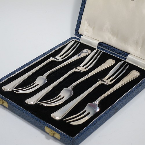 A Sterling Silver Art Deco style set of six pastry forks, having a double-struck plain reeded Athenian pattern handle, and three tined forks, all in their original cream satin and black velvet-lined presentation box. Made by Mappin and Webb of Sheffield in 1963. The dimensions of these fine hand-made silver pastry forks are length 13 cms (5.25 inches), and they weigh a total of 103g (3.3 troy ounces).    