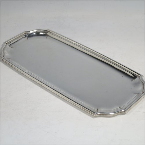 A Sterling Silver heavy Georgian style pen tray, having a rectangular body with shaped ends, a reeded and panelled border, and a plain ground, sitting on a flat base. Made by D. & J. Welby of London in 1927. The dimensions of this fine hand-made silver pen tray are length 22 cms (8.75 inches), width 10 cms (4 inches), and it weighs approx. 240g (7.7 troy ounces).    