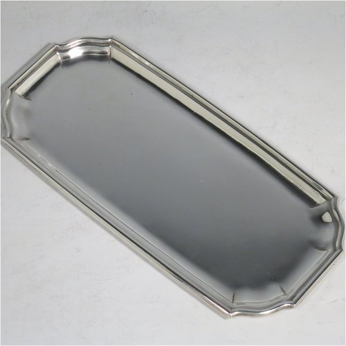 A Sterling Silver heavy Georgian style pen tray, having a rectangular body with shaped ends, a reeded and panelled border, and a plain ground, sitting on a flat base. Made by D. & J. Welby of London in 1927. The dimensions of this fine hand-made silver pen tray are length 22 cms (8.75 inches), width 10 cms (4 inches), and it weighs approx. 240g (7.7 troy ounces).    