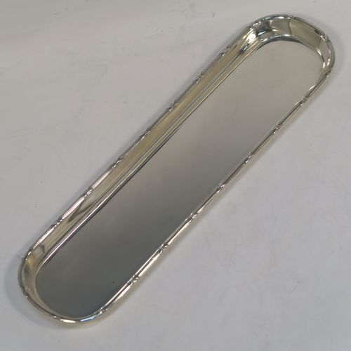 A very elegant Antique Sterling Silver pen tray, having a very plain rectangular body with rounded ends, an applied reed and ribbon border, and all sitting on a flat base. This handsome silver pen tray was made by Stokes and Ireland of Chester in 1914. The dimensions of this fine hand-made antique silver pen tray are length 24 cms (9.5 inches), width 6.5 cms (2.5 inches), and it weighs approx. 108g (3.5 troy ounces).   