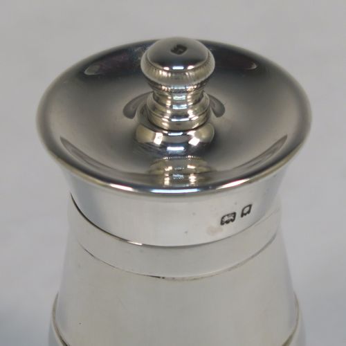 A very handsome Antique Edwardian Sterling Silver pepper grinder in a milk churn style, having a plain tapering straight sided body with three applied bands of decoration, with a knurled grinder finial, and a Peugeot grinder mechanism. This elegant antique silver pepper grinder was made by Goldsmiths and Silversmiths of London in 1903. The dimensions of this fine hand-made antique silver pepper grinder are height 8 cms (3 inches), and diameter at base 5 cms (2 inches).   