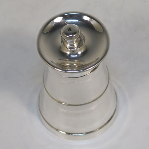 A very handsome Antique Edwardian Sterling Silver pepper grinder in a milk churn style, having a plain tapering straight sided body with three applied bands of decoration, with a knurled grinder finial, and a Peugeot grinder mechanism. This elegant antique silver pepper grinder was made by Goldsmiths and Silversmiths of London in 1903. The dimensions of this fine hand-made antique silver pepper grinder are height 8 cms (3 inches), and diameter at base 5 cms (2 inches).   