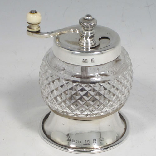 Antique Victorian sterling silver and hand-cut crystal pepper grinder, having a round body with hobnail-cut pattern, plain round mounts top and bottom, an opening for adding the pepper corns that is revealed by twisting the top mount, a side-winding grinder arm with ivory finial, and an original Peugeot grinding mechanism. Made in Birmingham in 1898. The dimensions of this fine hand-made silver and crystal pepper grinder are height 9 cms (3.5 inches), and diameter at base 6.5 cms (2.5 inches). 