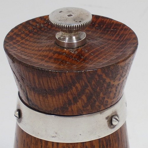 A handsome Sterling Silver and wooden pepper grinder in a milk churn style, having a plain tapering straight sided body with three applied and pinned silver bands, a knurled round finial, and an original Peugeot grinder mechanism. Made by Hukin and Heath of Birmingham in 1929. The dimensions of this fine hand-made silver and wooden pepper grinder are height 10 cms (4 inches), and diameter at base 5 cms (2 inches).    