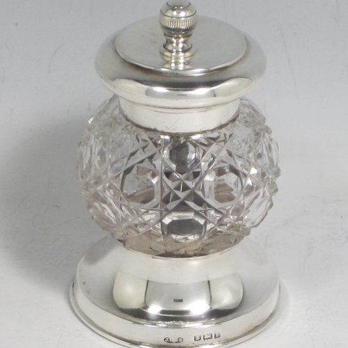 Antique Edwardian sterling silver and hand-cut crystal pepper grinder, having a round body with hobnail-cut pattern, plain round mounts top and bottom, and an original Peugeot grinding mechanism. Made John Grinsell of Birmingham in 1905. The dimensions of this fine hand-made silver and crystal pepper grinder are height 9 cms (3.5 inches), and diameter at base 6 cms (2.25 inches).    