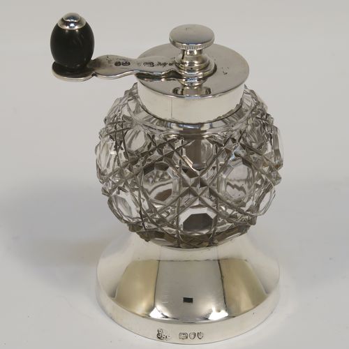 A handsome Antique Victorian Sterling Silver and hand-cut crystal pepper grinder, having a round body with hobnail-cut pattern, plain round mounts top and bottom, a side-winding grinder arm with wooden finial, and an original Peugeot grinding mechanism. This elegant antique pepper grinder was made by Heath and Middleton of London in 1891. The dimensions of this fine hand-made silver and crystal pepper grinder are height 9 cms (3.5 inches), and diameter at base 5 cms (2 inches).   