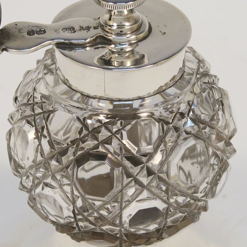 A handsome Antique Victorian Sterling Silver and hand-cut crystal pepper grinder, having a round body with hobnail-cut pattern, plain round mounts top and bottom, a side-winding grinder arm with wooden finial, and an original Peugeot grinding mechanism. This elegant antique pepper grinder was made by Heath and Middleton of London in 1891. The dimensions of this fine hand-made silver and crystal pepper grinder are height 9 cms (3.5 inches), and diameter at base 5 cms (2 inches).   