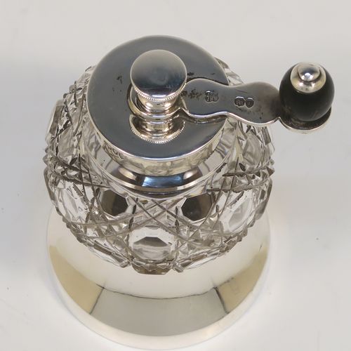 A handsome Antique Victorian Sterling Silver and hand-cut crystal pepper grinder, having a round body with hobnail-cut pattern, plain round mounts top and bottom, a side-winding grinder arm with wooden finial, and an original Peugeot grinding mechanism. This elegant antique pepper grinder was made by Heath and Middleton of London in 1891. The dimensions of this fine hand-made silver and crystal pepper grinder are height 9 cms (3.5 inches), and diameter at base 5 cms (2 inches).   