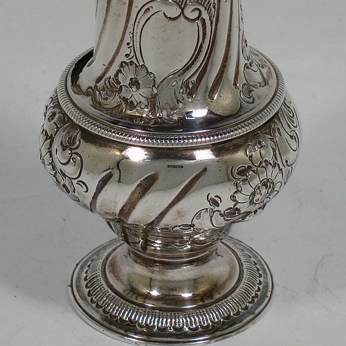 A very handsome Antique Georgian George III Sterling Silver pepper pot, having a baluster body with hand-chased fluted and floral decoration, applied rope-twist borders, a hand-pierced pull-off lid with urn finial, and sitting on a pedestal foot. Made by William Turton of London in 1777. The dimensions of this fine hand-made antique silver pepper pot are height 15 cms (6 inches), diameter of main body 6 cms (2.25 inches), and it weighs approx. 142g (4.6 troy ounces).    