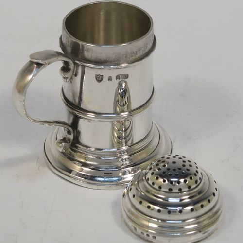 A very handsome Silver Kitchen pepper made in the Britannia Standard, having a plain round straight-sided body with an applied central girdle, a pull-off hand-pierced lid, a cast scroll side-handle, and siting on a stepped collet foot. This Britannia Standard silver kitchen pepper pot was made by the Pairpoint Brothers of London in 1929. The dimension of this silver kitchen pepper are height 7.5 cms (3 inches), length 7 cms (2.75 inches), and it weighs approx. 149g (4.8 troy ounce).   